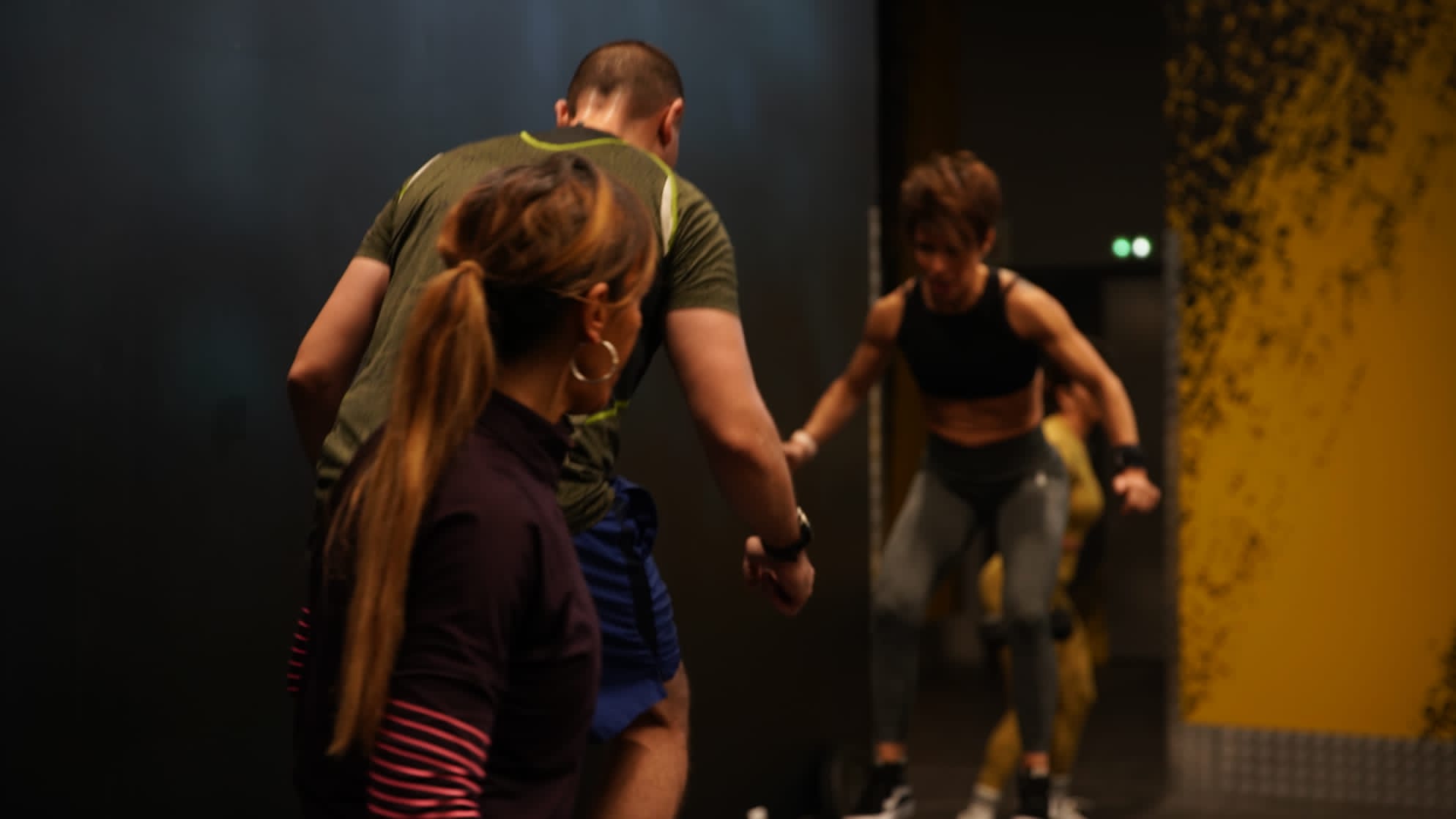 Young woman personal trainer helping with workout at gym