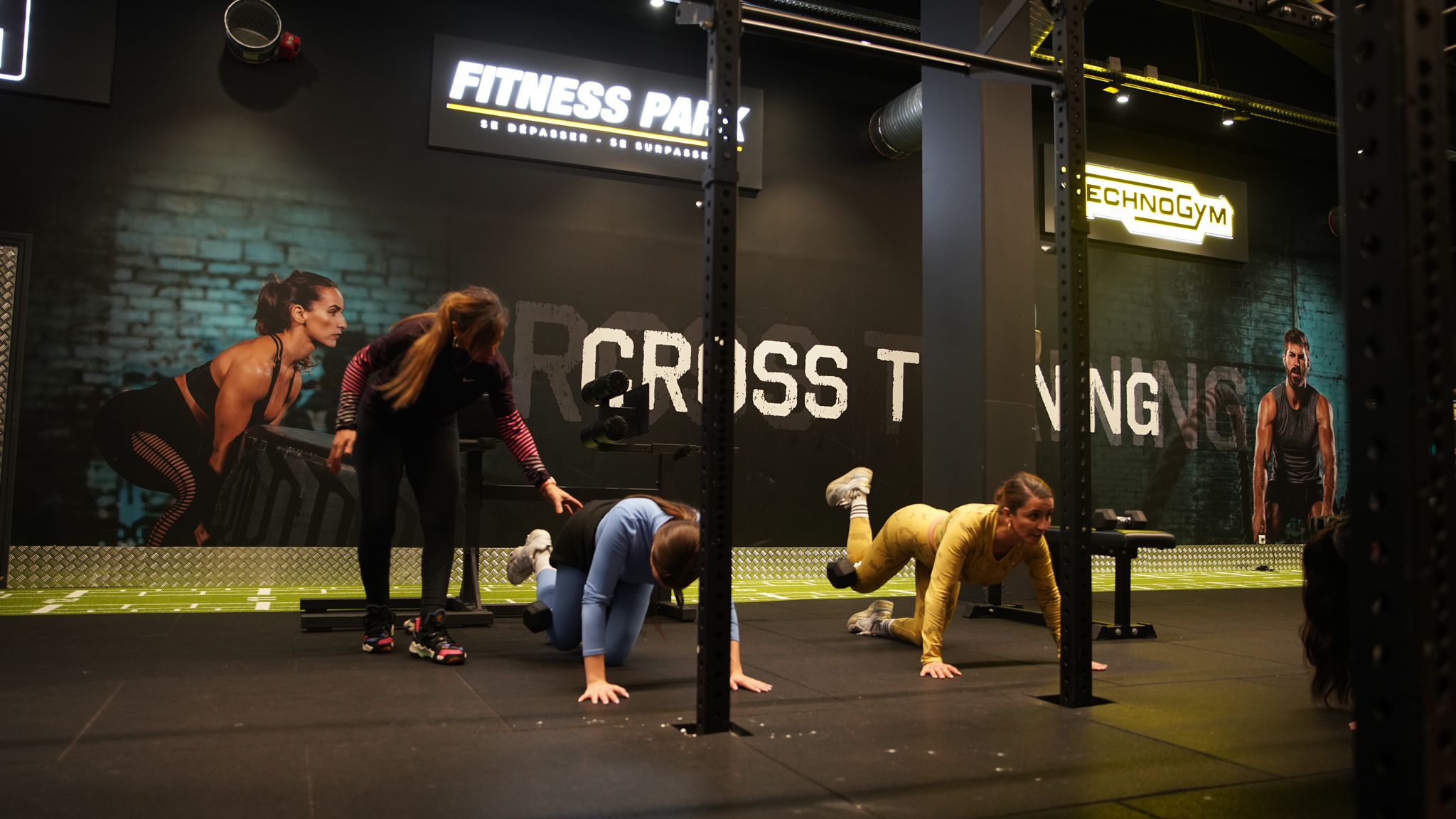 Young woman personal trainer helping with workout at gym